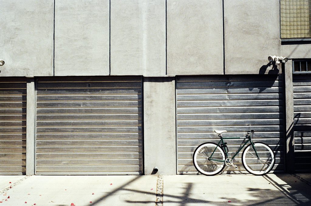 Un vélo posé devant une porte de garage