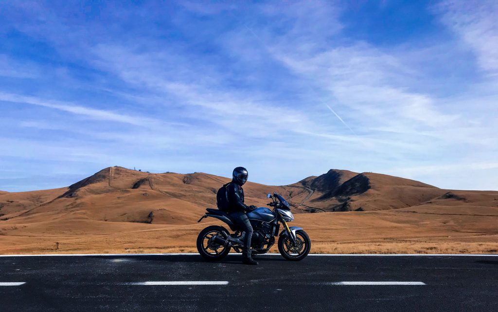 Motard sur une route, au milieu du désert